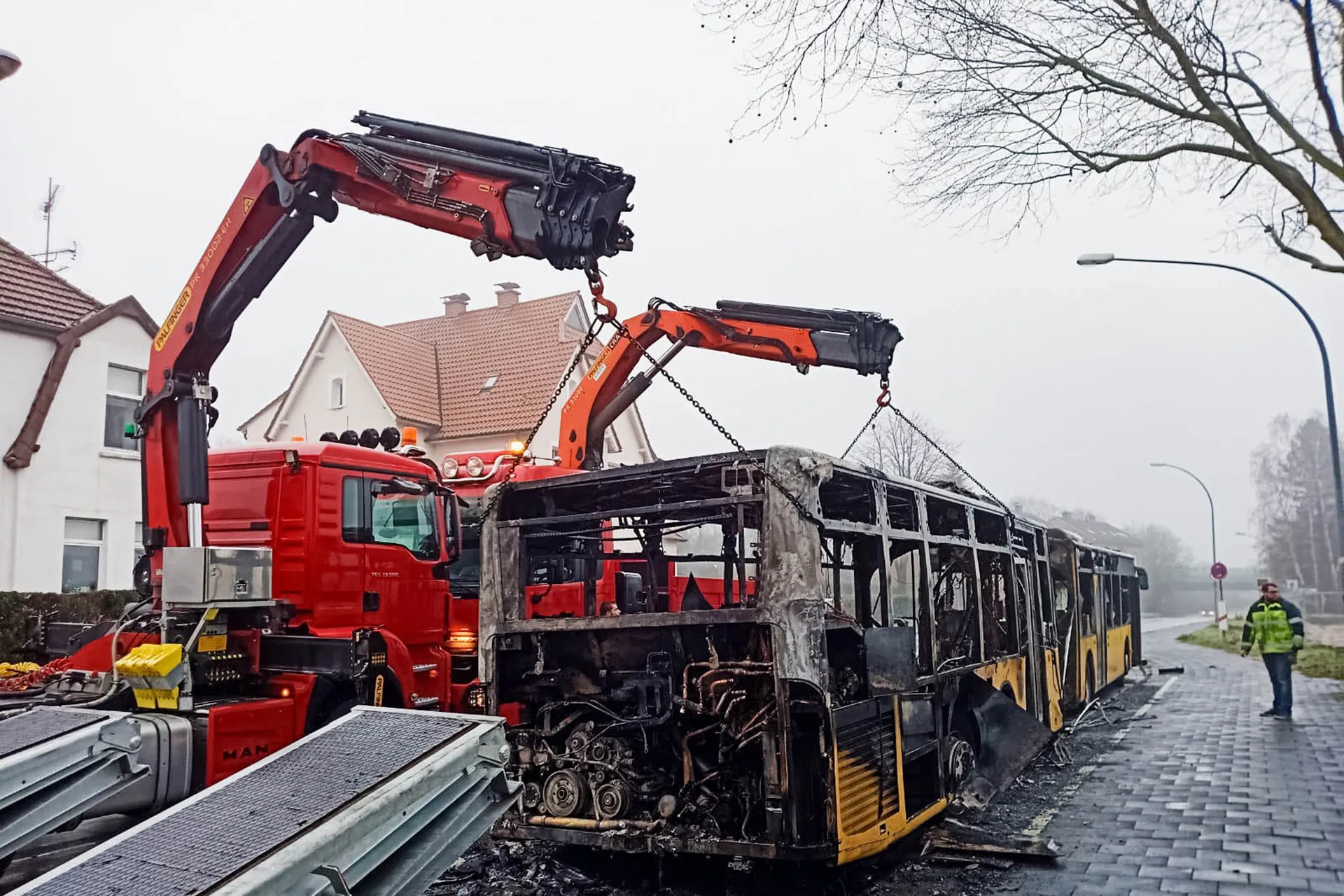 Bergung eines ausgebrannten Busses mit Ladekränen von Spezialtransportern