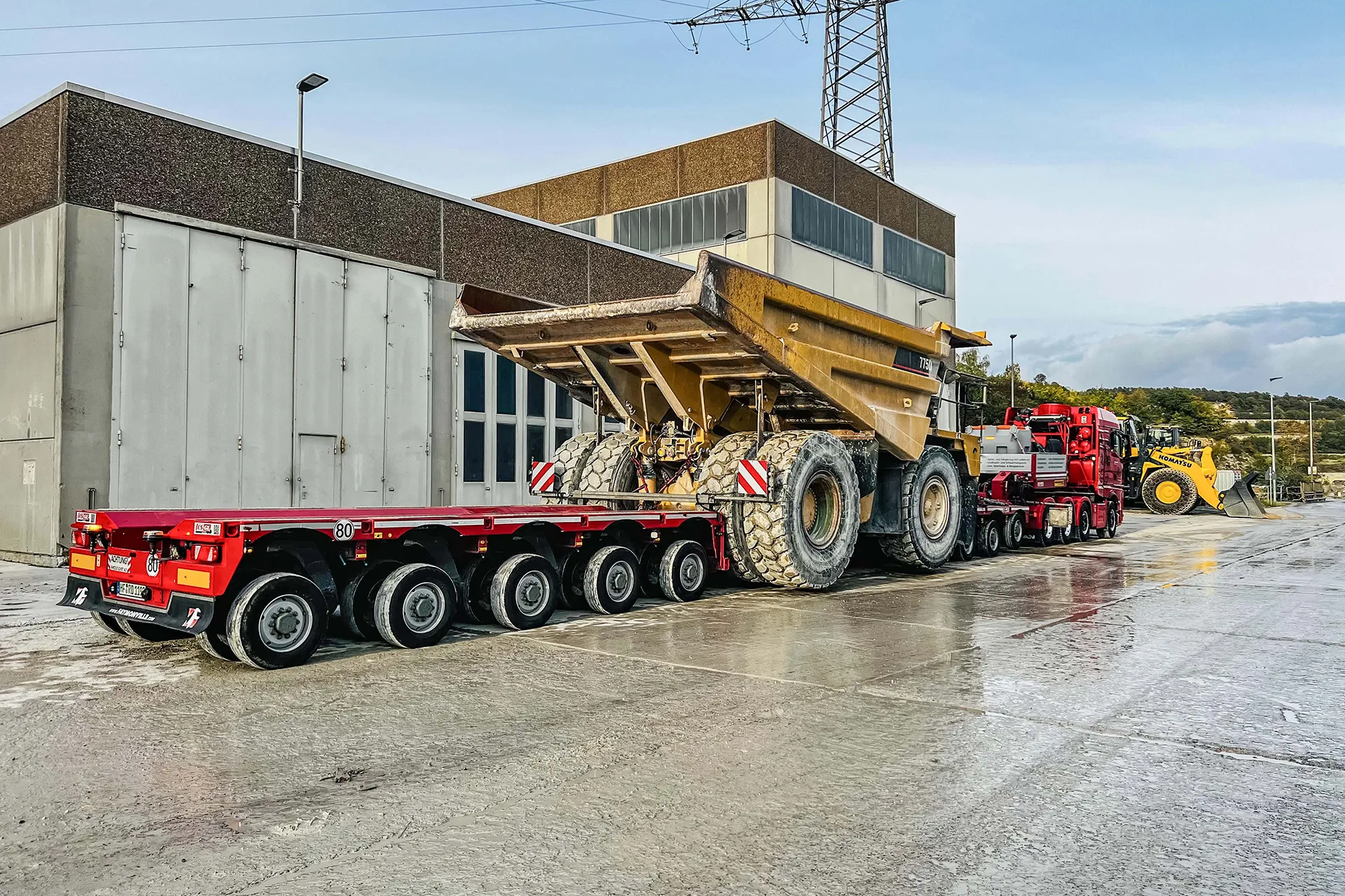 Schwertransport fährt durch ein Industriegebiet mit einer Stahlkonstruktion
